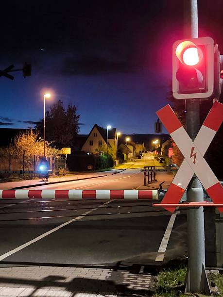 istock A railroad crossing with a red traffic light and a barrier at night 2241892907