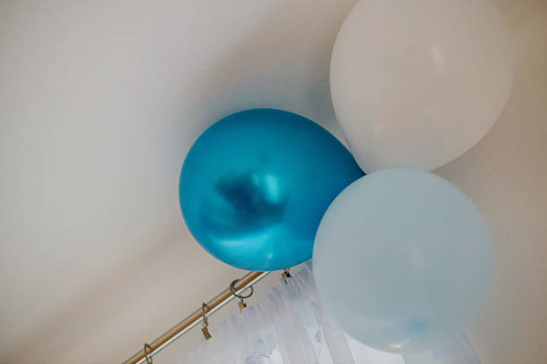 Close up of blue balloon with stars on pink background after party
