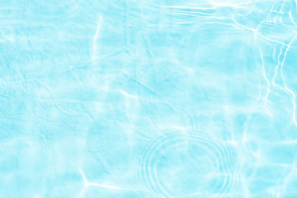 Natural background of water in summer. Blue surface. Clear water with ripples and splashes. water waves in sunlight The water surface has waves.