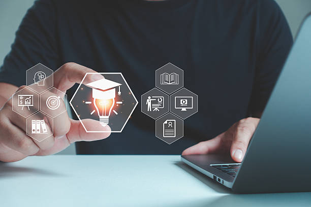 istock Person interacting with a laptop, touching an icon of a lightbulb with educational and business symbols around it, representing online learning, innovation and digital education. 2241900373