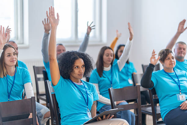 istock Volunteers raising hands during a conference meeting 2241900431