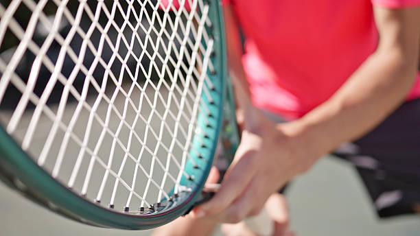 istock Tennis Player Practicing on Hardcourt, Focusing on Racket Strings 2241900657