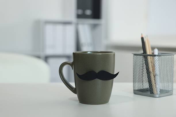 istock Happy Father's Day. Cup with paper moustache on white table indoors 2241901627