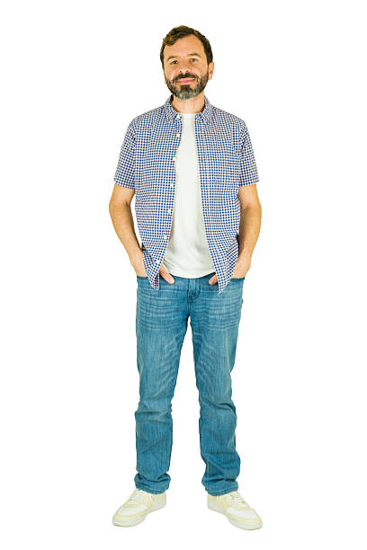 Happy man smiling, standing full length with hands in pockets, wearing casual checkered shirt and jeans, white background