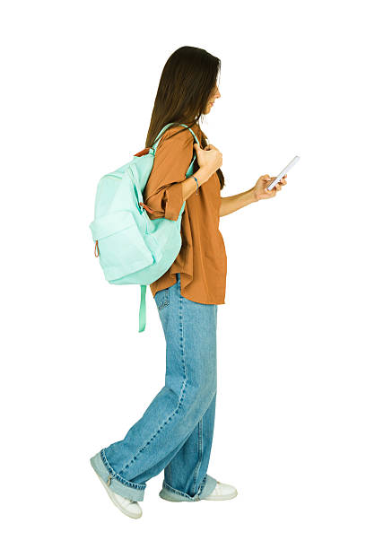 istock Profilew view of a woman walking using smartphone on white background 2241903264