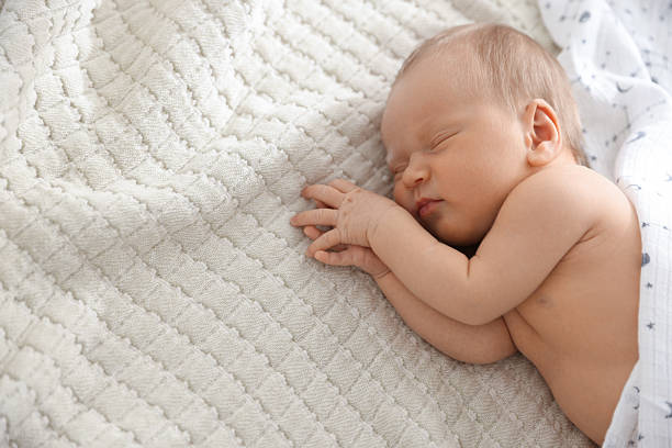 istock Cute newborn baby sleeping on bed, top view. Space for text 2241903358