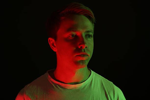 istock Handsome man in neon lights against black background 2241903544