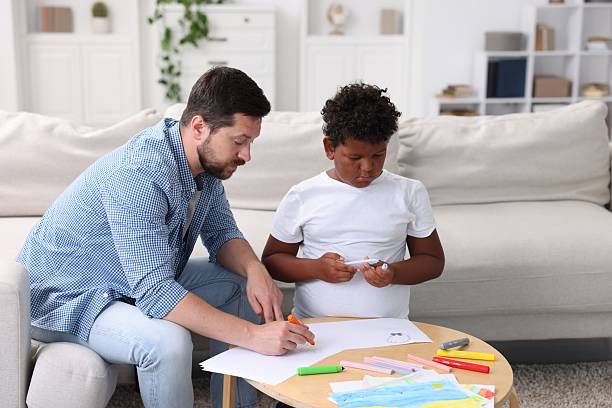 istock Adoption. Father and his son drawing together at table indoors 2241903929