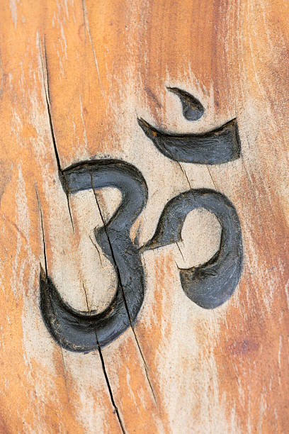 sacred Om symbol carved in wood background
