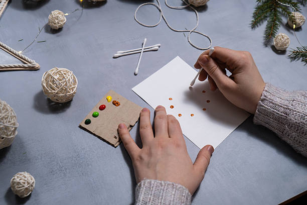 istock Christmas wreath Storytelling of creating craft Christmas greeting card holiday present. Tactile hand-on activity. Master class progress of creative me-made gifts. Seasonal domestic life micro moment hobby. 2241907708