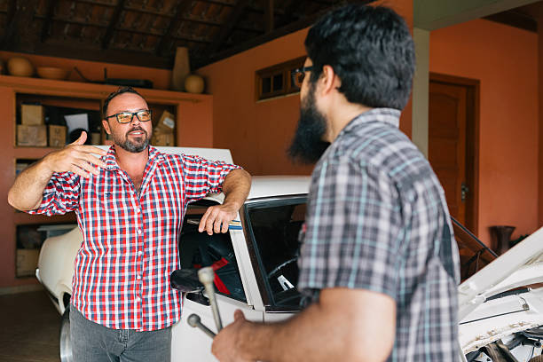 istock Two men discussing classic muscle car in garage 2241915240