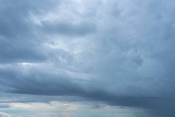 A vast expanse of a heavily overcast sky dominated by dark dense stratocumulus clouds suggesting impending rain or a storm over the horizon