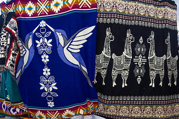 Colorful traditional wool rugs and blankets with Andean designs are sold at the Plaza de los Ponchos artisan market in Otavalo, Imbabura Province, Ecuador