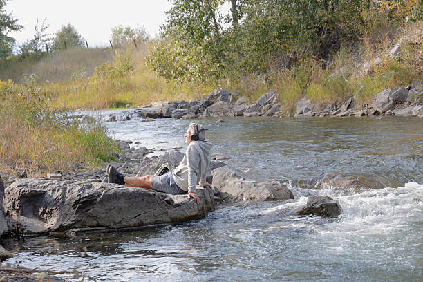 istock Mature man relaxes on riverbank 2241926178