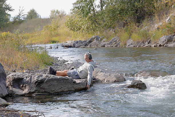 istock Mature man relaxes on riverbank 2241926187