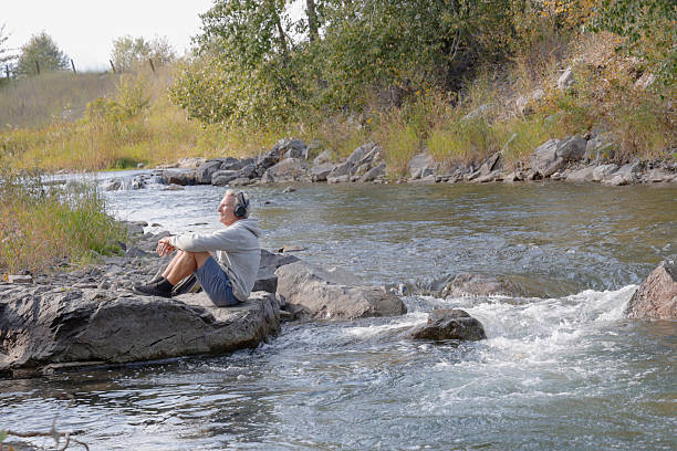 istock Mature man relaxes on riverbank 2241926195