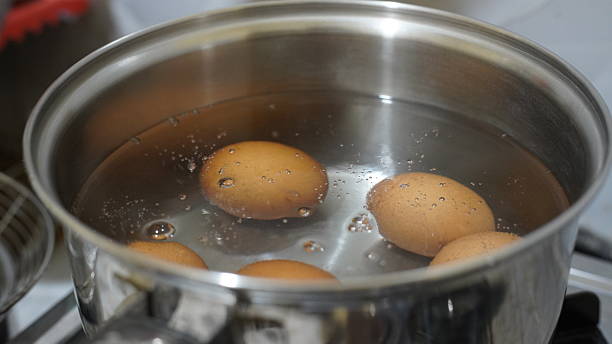 istock Several brown eggs are being boiled in simmering water inside a stainless steel pot, showing the process of cooking 2241928557