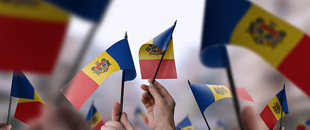 istock Moldavia flags in their hands on a blurred urban background 2241928731