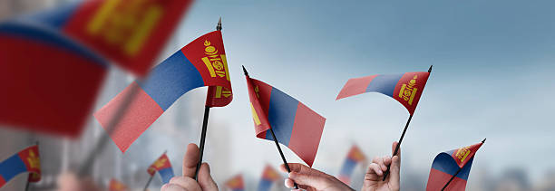 istock Mongolia flags in their hands on a blurred urban background 2241928760