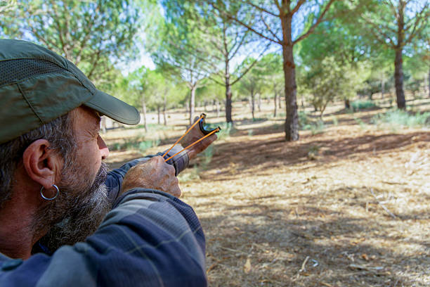 istock Man aiming slingshot in forest for hunting 2241929002
