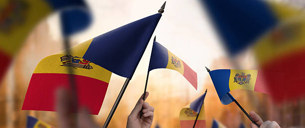 istock Moldavia flags in their hands on a blurred urban background 2241929156