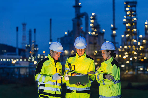 istock Group of Engineers team night shift working oil and gas refinery service, Workers hard work at night petroleum industry plant background. 2241934173