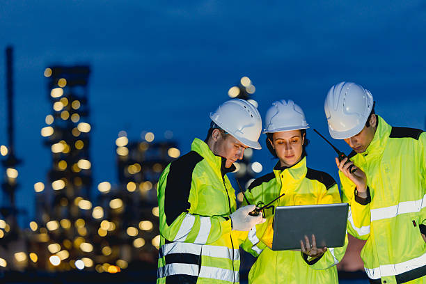 istock Group of Engineers team night shift working oil and gas refinery service, Workers hard work at night petroleum industry plant background. 2241934181