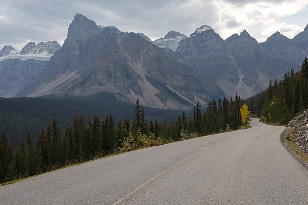istock Empty road, forest and snowcapped mountain range, Canadian Rockies 2241934469
