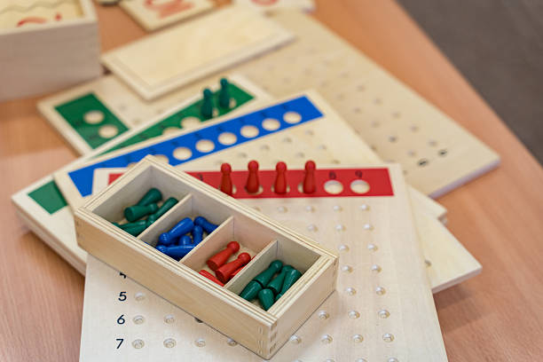 istock Montessori education. Wooden chips in a box and boards for alternative learning and understanding of division in mathematics on a blurred background. 2241939873