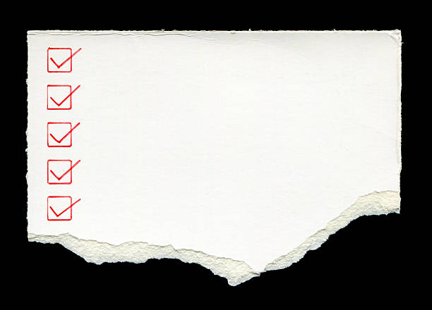 Cut or torn lined paper background with checklist isolated on black.