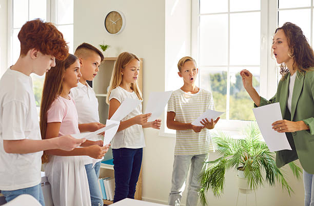 istock Teacher And Students Singing In School Music Class 2241946018