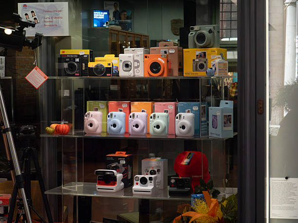 Pisa, Italy - October 16th 2025 Shop window displaying a collection of colorful instant cameras and their packaging, showcasing modern and retro models for sale
