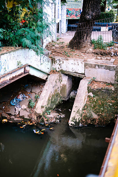 istock Urban Waterway with Concrete Banks, Graffiti and Debris 2241947229