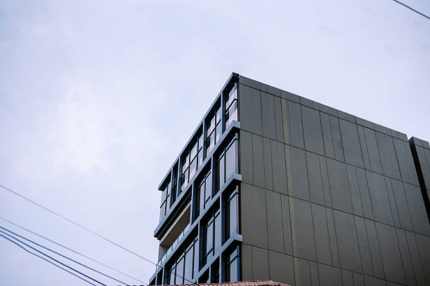 istock Modern high-rise building with dark facade against cloudy sky 2241949048