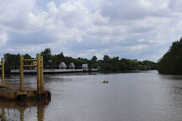 istock Peaceful river scene, lush greenery surrounding calm waters, distant wooden bridge connecting both shores, serene atmosphere inviting reflection. 2241949123