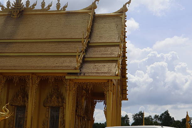 Golden architectural structure against a cloudy sky, intricate details and modern design, suitable for travel or culture themes.