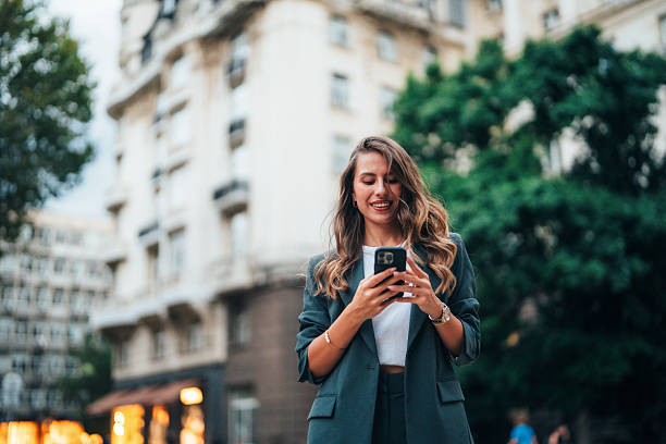istock Smiling woman using smartphone 2241951044