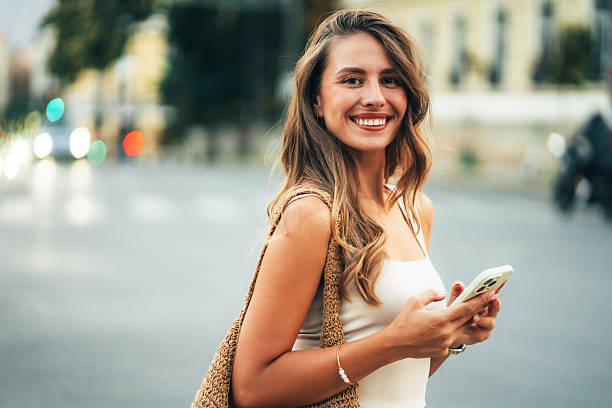 istock Beautiful woman using mobile in the street 2241951045