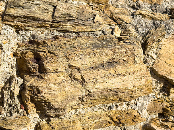 istock Close-up of weathered stone wall with rough texture 2241951387