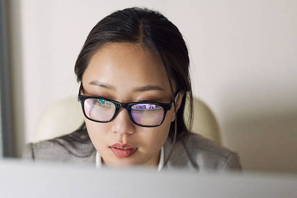 istock Young Businesswoman in Glasses Looking at Computer Screen 2241954376
