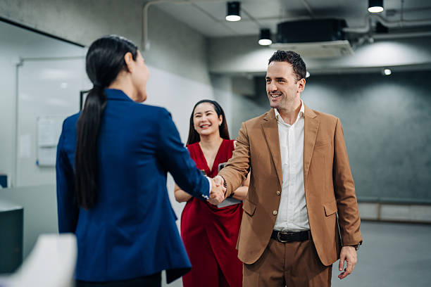istock Business professionals greeting each other with handshake in modern office 2241958452