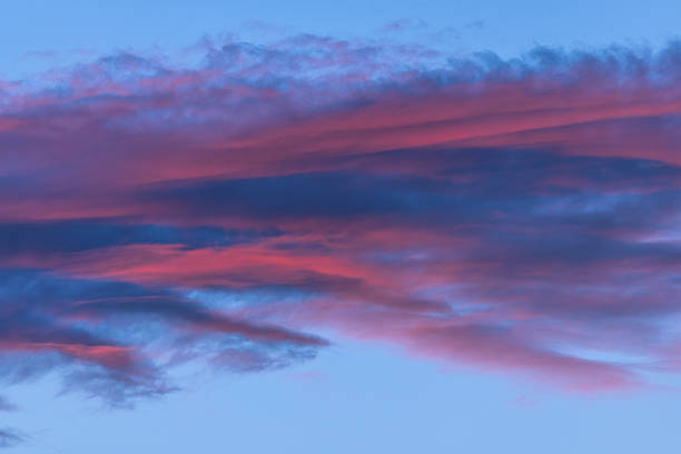 Beautiful sky with twilight shows pink and blue clouds. Colors are expecting day that day gives way to night. Scene is calm and peaceful.