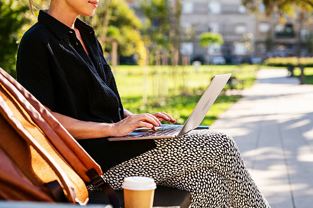 istock Female person using laptop outdoors in city. 2241959633