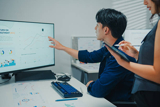 istock Two Asian colleagues collaborating meeting with team members discussing strategy in the modern office. Office Meeting, Team Discussion, Strategic Collaboration Concept. 2241968663