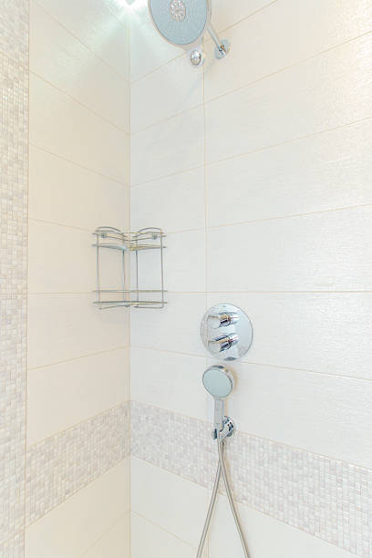istock A corner shower with a white tile wall and a chrome shower head 2241969415
