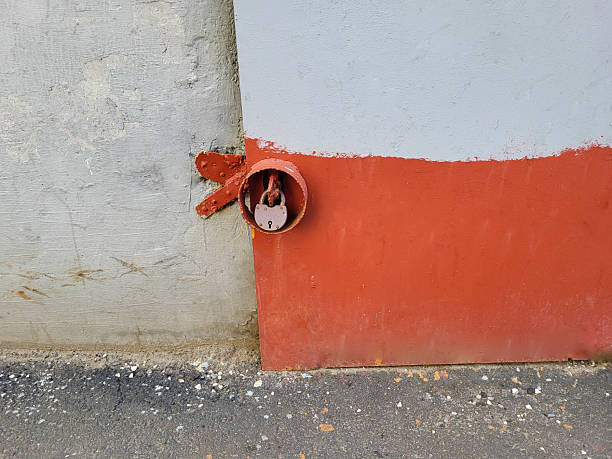 An old lock hangs on the painted iron door outside