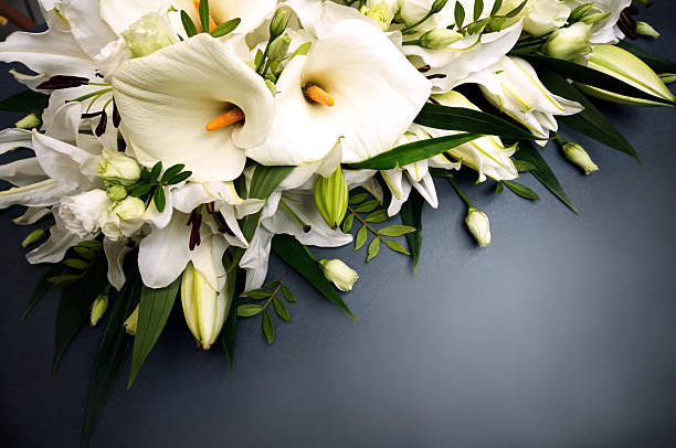 A beautiful bouquet of white lilies and carnations, creating a delicate and elegant composition in soft natural light.