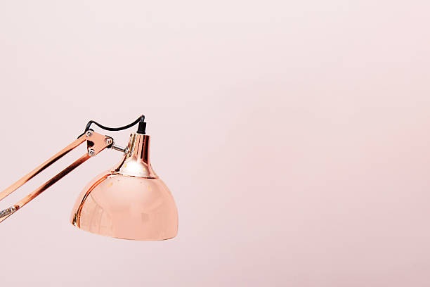 istock A rose gold folding lamp with a plain pink background 2241971276