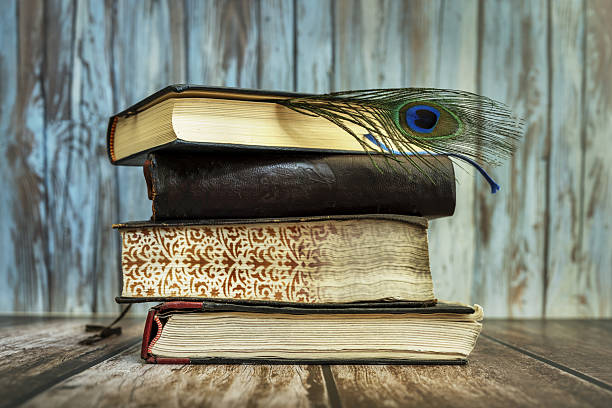 istock A stack of old books along with a peacock feather 2241971430