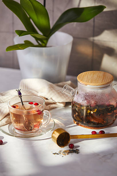 istock Fruits and berries tea. Glass teapot and cup on the table 2241975444